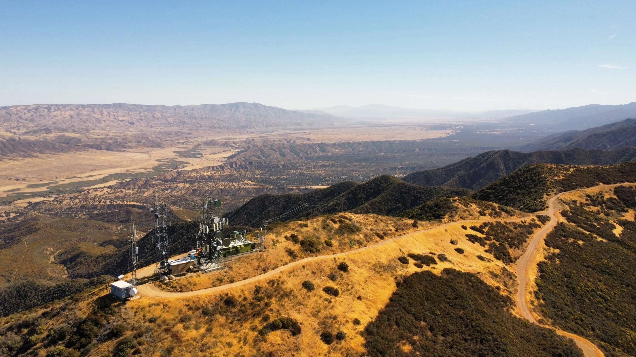 Cell tower on a mountain overlooking a valley